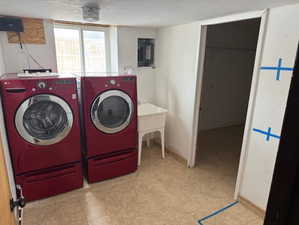 Clothes washing area featuring independent washer and dryer and electric panel