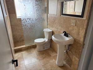 Bathroom with a tile shower and toilet