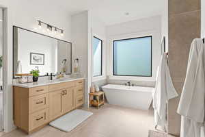 Bathroom featuring tile patterned flooring, vanity, and a bathing tub