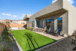 Rear view of property featuring a yard and a patio