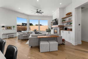 Living room with light hardwood / wood-style flooring and ceiling fan