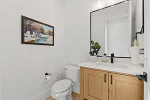 Bathroom featuring hardwood / wood-style floors, vanity, and toilet