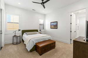 Bedroom with ceiling fan and light colored carpet