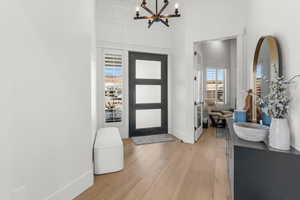 Entrance foyer with light hardwood / wood-style flooring and a notable chandelier