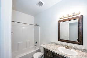 Full bathroom featuring vanity,  shower combination, and toilet