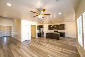 Kitchen with appliances with stainless steel finishes, a wealth of natural light, pendant lighting, and an island with sink