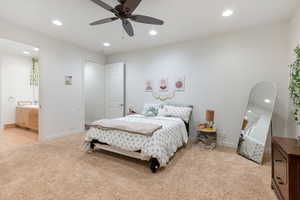 Bedroom with ensuite bathroom, ceiling fan, and light carpet