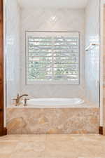 Bathroom with a wealth of natural light and tiled tub