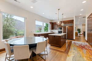 Kitchen featuring paneled refrigerator, pendant lighting, light hardwood / wood-style flooring, a mountain view, and a center island