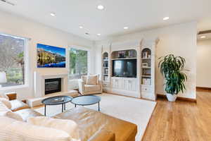 Living room with a healthy amount of sunlight and light hardwood / wood-style floors