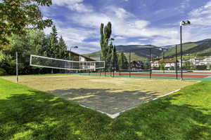 View of home's community with volleyball court, a mountain view, a yard, and tennis court