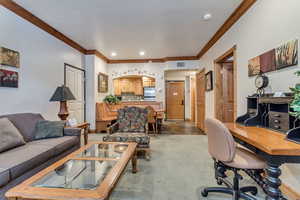 Living room with carpet flooring and crown molding