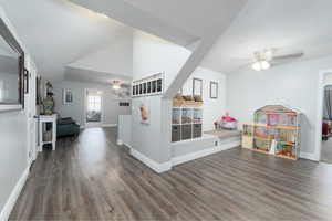 Playroom with vaulted ceiling, ceiling fan, and dark wood-type flooring