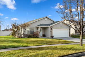 Ranch-style home with a garage and a front lawn