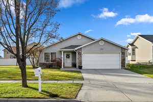 Ranch-style house with a front yard and a garage