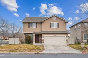 View of property with a garage and a front yard