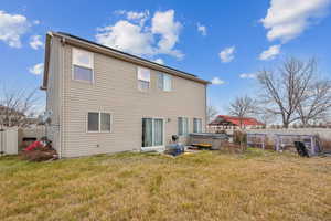 Back of house featuring a yard and a hot tub