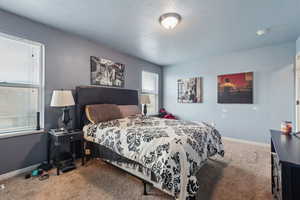 Carpeted bedroom with a textured ceiling