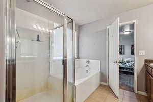 Bathroom with plus walk in shower, vanity, and tile patterned floors