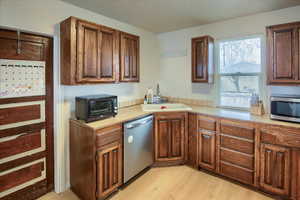 Kitchen featuring sink, stainless steel appliances, and light hardwood / wood-style flooring