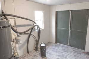 Interior space with strapped water heater and light hardwood / wood-style flooring