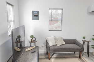 Sitting room with a wall mounted AC and hardwood / wood-style floors