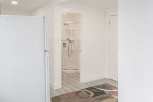 Bathroom with a shower and hardwood / wood-style flooring