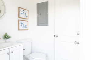 Bathroom with vanity, electric panel, and toilet