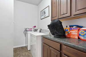 Laundry area featuring cabinets and washer and dryer