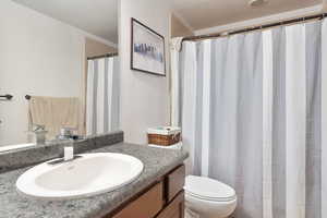 Bathroom featuring vanity, a textured ceiling, and toilet