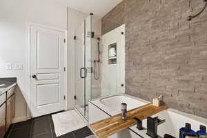 Bathroom with tile patterned floors, vanity, separate shower and tub, and a textured ceiling