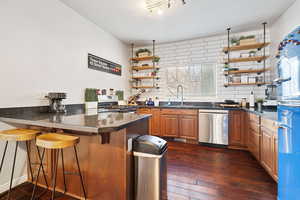 Kitchen with a kitchen breakfast bar, sink, kitchen peninsula, and white gas range oven