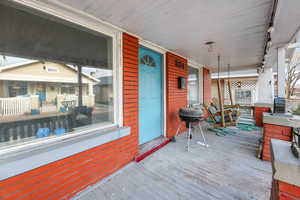 Wooden terrace featuring grilling area and a porch