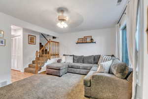 Living room with carpet floors and ceiling fan