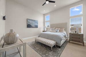 Bedroom with light carpet, a towering ceiling, baseboards, and recessed lighting