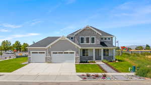 Craftsman inspired home with a front lawn, a porch, and a garage