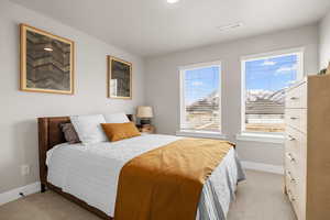 Bedroom featuring baseboards, visible vents, and light colored carpet