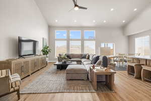 Living area featuring ceiling fan, high vaulted ceiling, light wood-style flooring, and recessed lighting