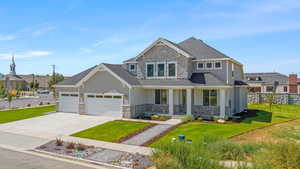 Craftsman inspired home featuring covered porch, a front yard, and a garage