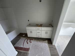 Bathroom featuring hardwood / wood-style flooring, vanity, and a tub