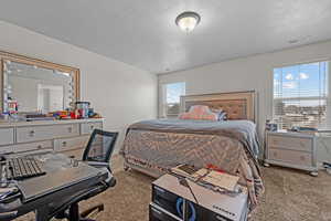 Carpeted bedroom with a textured ceiling