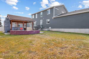 Back of house featuring a lawn and a patio area