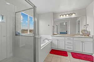 Bathroom with tile patterned flooring, plus walk in shower, and vanity