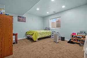 Bedroom with a textured ceiling and carpet