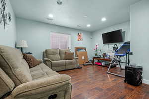 Living room featuring a textured ceiling and dark hardwood / wood-style flooring