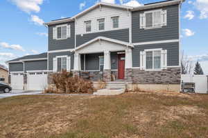 Craftsman-style house with covered porch, a front yard, and a garage