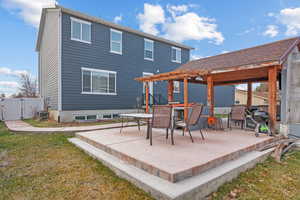 Rear view of house featuring a yard, cooling unit, and a patio