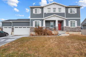 View of front of property with a front yard, a garage, and covered porch