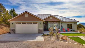 View of front of house with a patio, a front yard, and a garage