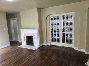 Unfurnished living room featuring dark hardwood / wood-style flooring and a tile fireplace